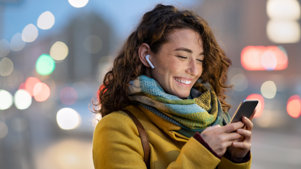 Customer Experience in der Telekommunikation_Frau lacht mit Mobiltelefon