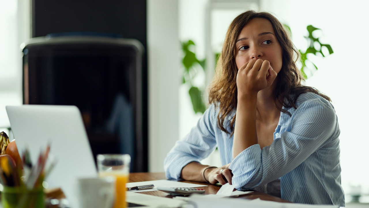 Frau mit besorgtem Gesichtsausdruck am Arbeitsplatz, ein Anzeichen für Quiet Quitting